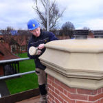 Stone mason Adam Harris working on Quadrangle chimney